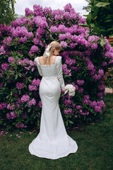 Bride on a background of lilac flowers.Wedding bouquet of white peonies. Significant day.
