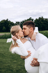 The newlyweds frolic barefoot on a green meadow. Summer day.