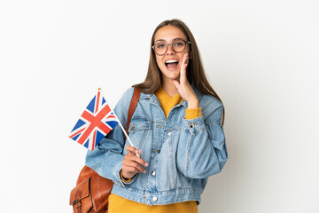 Young hispanic woman holding an United Kingdom flag over isolated white background shouting with mouth wide open