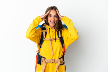 Young mountaineer woman with a big backpack over isolated white background with surprise expression