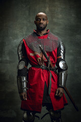 Vintage style portrait of brutal dark skinned man, medieval warrior or knight with wounded face...