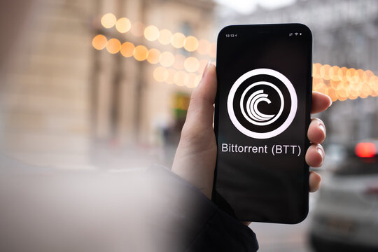 Bittorrent BTT coin symbol. Trade with cryptocurrency, digital and virtual money, mobile banking. Hand with smartphone, screen with crypto icon close-up photo
