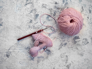 The beginning of crocheting a little angel from yarn in white and pink lights