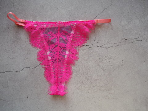 Burgundy crimson lace guipure thong for women on a gray background. High quality photo