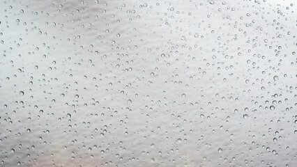 Water drops on glass on snow background