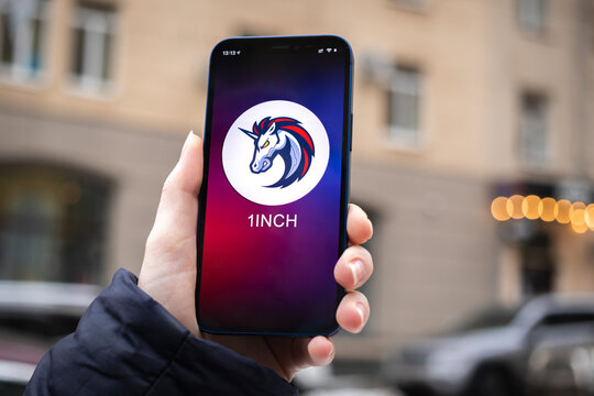 1INCH symbol. Trade with cryptocurrency, digital and virtual money, mobile banking. Hand with smartphone, screen with crypto icon close-up. Business and financial concept photo