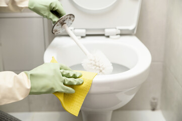 cleaning the toilet with different detergents use rubber gloves and a rag with a brush.