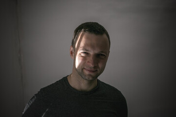 Portrait of young smiling man standing in shadow