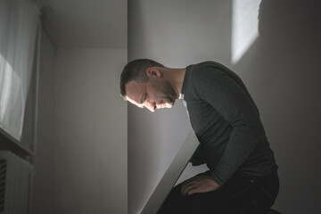 Young man looking in the mirror in a dark room