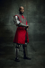 Vintage style portrait of brutal dark skinned man, medieval warrior or knight with wounded face...