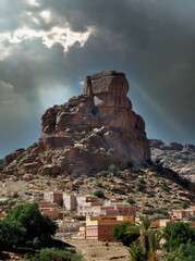 Poblado de casas al pie de un enorme cerro rocoso en Tafraoute (Marruecos) iluminado por un...