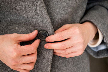 Obraz premium close-up of a person buttoning her jacket