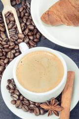 Breakfast consisting of fresh croissant with chocolate and coffee in cup