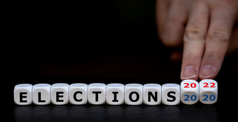 Symbol for the midterm election 2022 in the United States. Hand turns dice and changes the expression 