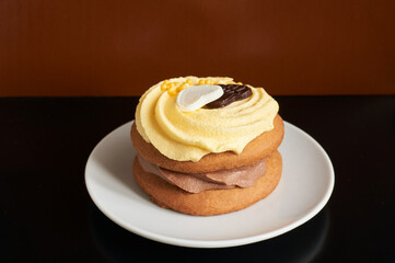 Yellow banana cupcake on white plate on black and brown background
