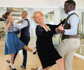 Woman pensioner with african man practising charleston - obrazy, fototapety, plakaty