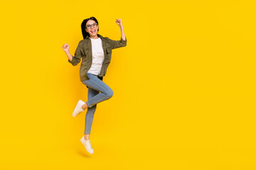Fototapeta na wymiar Full size photo of celebrate young lady jump wear eyewear shirt jeans sneakers isolated on yellow background
