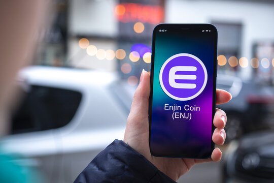Enjin ENJ coin symbol. Trade with cryptocurrency, digital and virtual money, mobile banking. Hand with smartphone, screen with crypto icon close-up photo