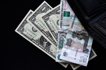 Dollar bills and rubles from a black wallet