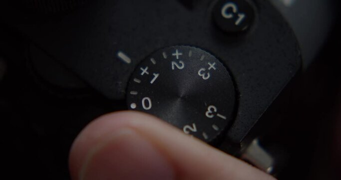 A finger adjusts the wheel of a camera, close shot