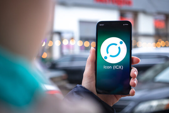 Icon ICX coin symbol. Trade with cryptocurrency, digital and virtual money, mobile banking. Hand with smartphone, screen with crypto icon close-up photo