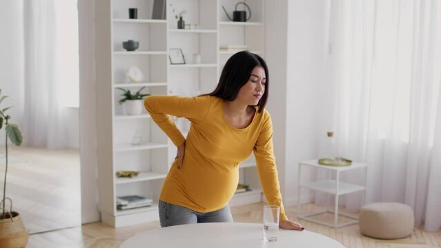 Labor Pain. Pregnant Asian Woman Suffering Painful Contractions At Home