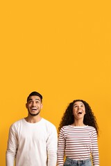 Portrait Of Amazed Young Arab Couple Looking Up With Opened Mouth