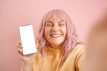 Portraif of young 20s woman holding smartphone with white blank screen, showing mockup template