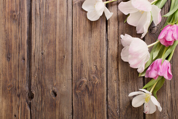Fototapeta na wymiar beautiful tulips on old dark wooden background