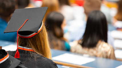 Remise de diplômes à l'université - Jeune étudiante portant une coiffe universitaire - obrazy, fototapety, plakaty
