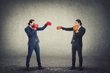 Face you own fears business metaphor as a businessman with boxing gloves confronts his office clone...
