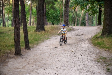 Cyclist Riding down the sandy Hill on the Offroad Trail