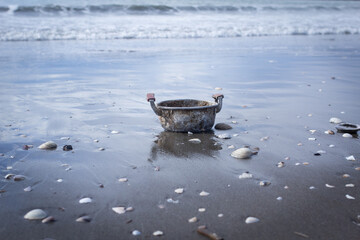砂浜に放置される錆びれた鍋