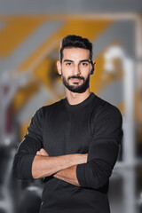 Fototapeta na wymiar Bearded arabian sportsman looking at camera in blurred sports center.