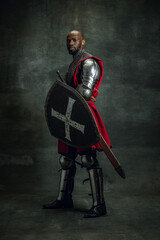 Vintage style portrait of brutal dark skinned man, medieval warrior or knight with wounded face...