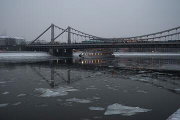 Grey city background with mystery atmosphere of the bridge and river with ice