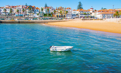 Panoramic view of sandy bay from city - Cascais, portuguese coast at Atlantic. Fishing boat with...