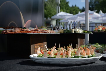 appetizer of cucumber with shrimp and cream cheese on a skewer closeup on a white plate. horizontal