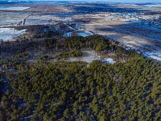 High above flight over winter forests and fields,