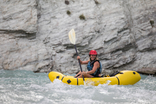 Side view of female paddler in a river canyon.