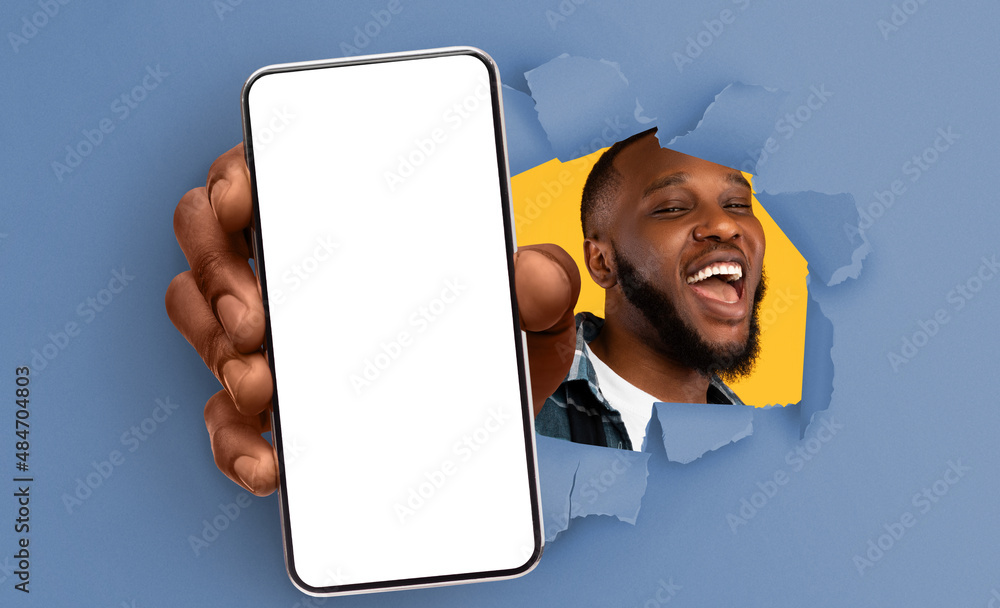 Poster black guy showing white empty smartphone screen through torn paper