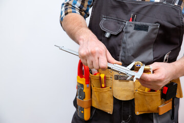 A worker measures the size of a part. Caliper in hand. Close-up.