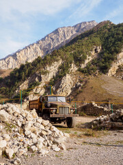 Old truck stands against the background of mountains