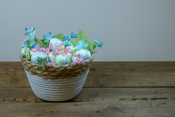 easter eggs in a basket with flowers