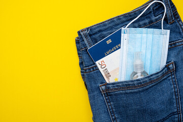 Pocket with jeans passport money and protective mask. Pandemic travel concept.