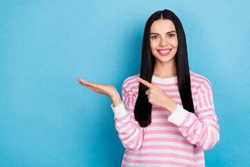 Photo of young girl indicate finger promo ad decide recommend proposition isolated over blue color background