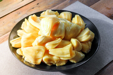 Thai fruit, fresh jackfruit placed in a black plate on a wooden table.