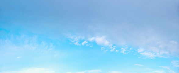 turquoise blue sky with light grey half above and some white cumulus clouds