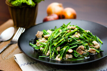 Stir-fried morning glory in a black dish 