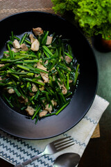 Stir-fried morning glory in a black dish 